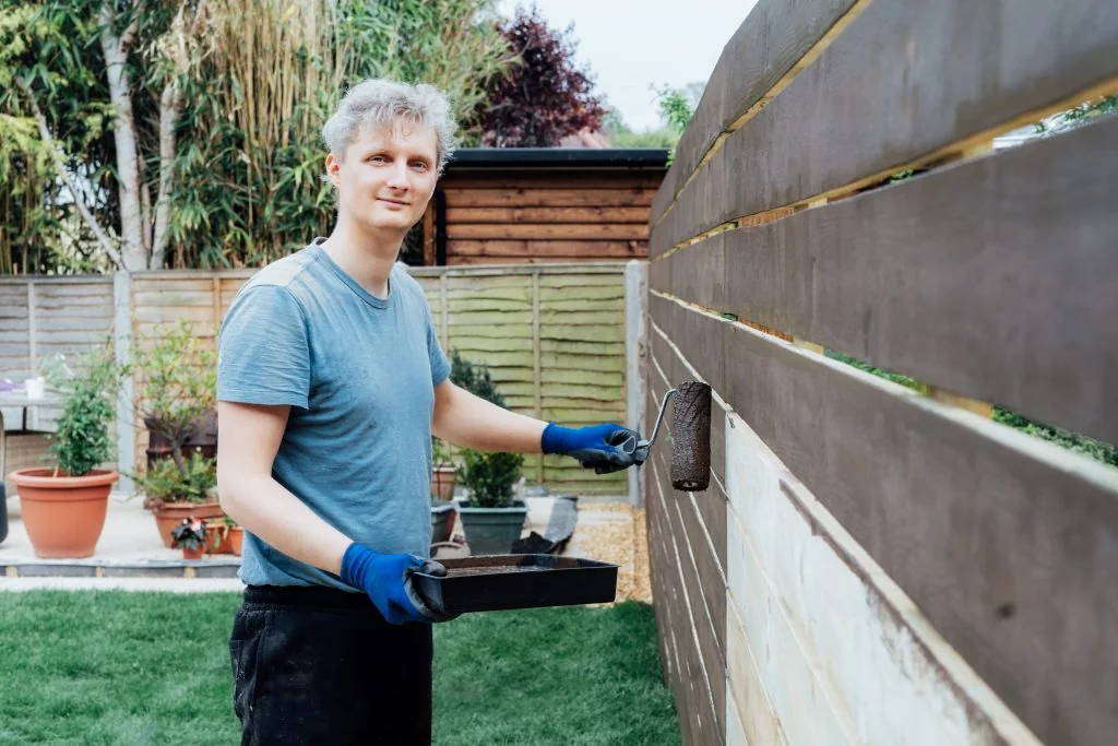 young man worker paints with roller a wooden board 2025 02 12 06 08 02 utc